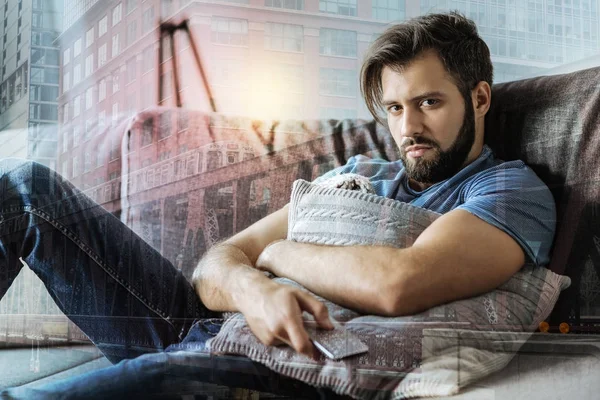 Deep exhausted man hugging the pillow and looking straight. — Stock Photo, Image