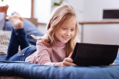 Gülümseyen sevimli kız onun tablet kullanma