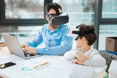 Baba ve oğul ofiste konuşmak Vr kulaklıklar içinde