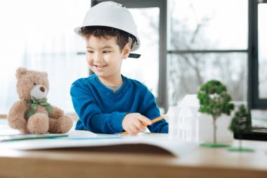 Küçük çocuk bir ayı Mimarlar Office ile oynarken