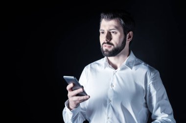 Bir akıllı telefon kullanan ciddi yakışıklı adam