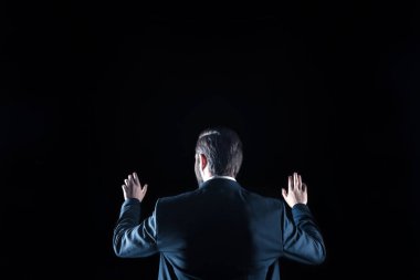 Siyah arka plan üzerinde duran profesyonel akıllı iş adamı