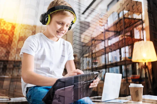 Bambino sorridente usando il suo nuovo tablet e guardando felice — Foto Stock