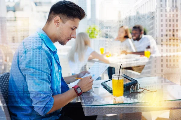 Concentrated male person writing notices — Stock Photo, Image