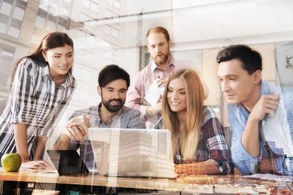 Cheerful young colleagues using laptop — Stock Photo, Image