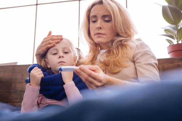 Troublé jeune mère tenant le thermomètre — Photo