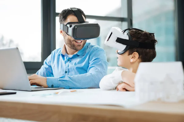 Vrolijke vader en zoon in Vr hoofdtelefoons ervaring te bespreken — Stockfoto