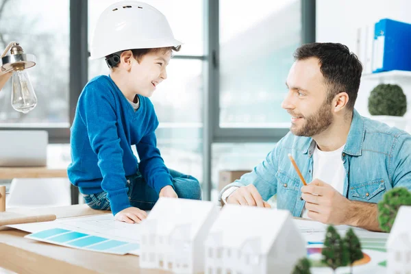Jovem arquiteto explicando seu projeto para o pequeno filho — Fotografia de Stock