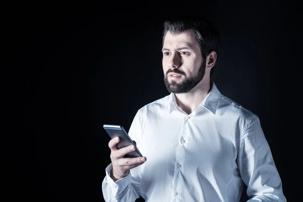 Ernstige knappe man met behulp van een smartphone — Stockfoto