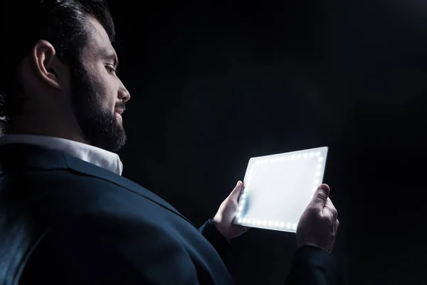 Empresário positivo alegre olhando para seu tablet — Fotografia de Stock