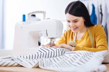 Dikiş makinesi oturma ve bir bluz yapmaya yetenekli terzi deneyimli
