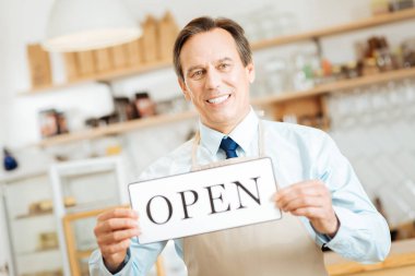 Düz seyir ve plaka gösterilen neşeli memnun adam.