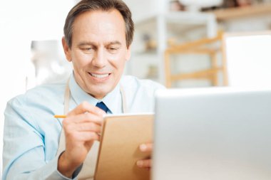 Oturma ve onun not defterinde yazılı hoş güvenilir girişimci.