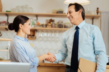 Kendine güvenen ayakta meslektaşları gülümseyen ve el sallayarak.