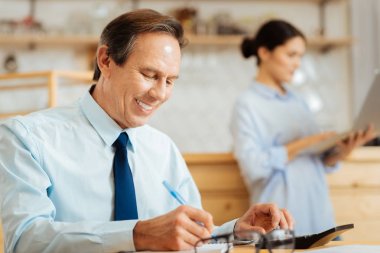 Joyful oturan adam ve yazma not defterinde işgal.