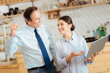 Laptop ile ayakta ve sevindirici akıllı başarılı iş arkadaşları .