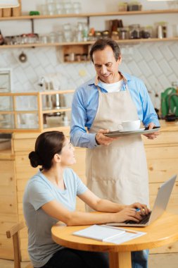 Ayakta ve his tutan yakışıklı güvenilir garson.