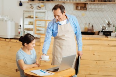 Ayakta ve kupa vererek neşeli kibar adam.