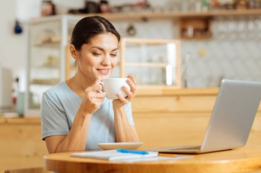 Oturma ve kahve içme tatmin genç kadın.