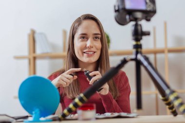 Kameraya bakarak ve yeni bir kapatıcı gösterilen duygusal blogger