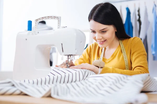 Красивая женщина шитье с помощью профессионального оборудования — стоковое фото