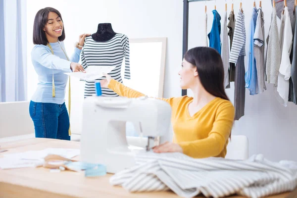 Sastre positivo dando a su colega un boceto de un vestido nuevo —  Fotos de Stock