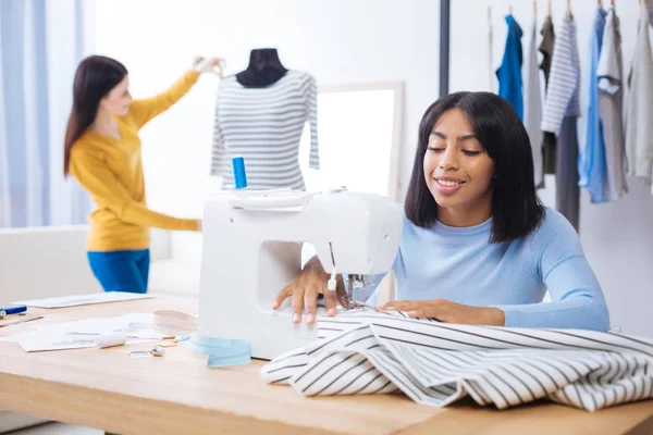 Atenta costura sastre mientras su compañero de trabajo mirando la blusa lista — Foto de Stock