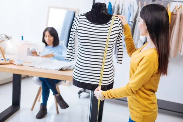 Attente op maat meten van de lengte van een gestreepte blouse — Stockfoto