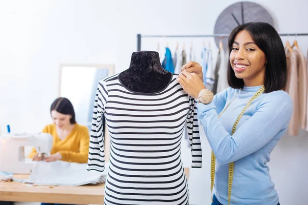 Mooie vrouw die lacht terwijl je met haar handen aanraken van de etalagepop — Stockfoto