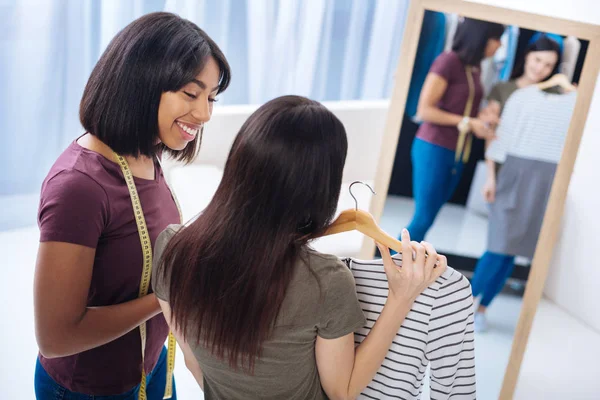 Sastre positivo sonriendo mientras mira a su cliente satisfecho —  Fotos de Stock