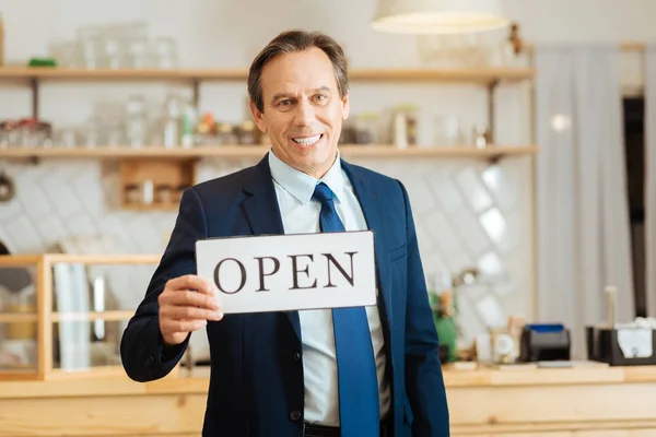 Senior hombre de negocios feliz de pie y sosteniendo la placa . —  Fotos de Stock