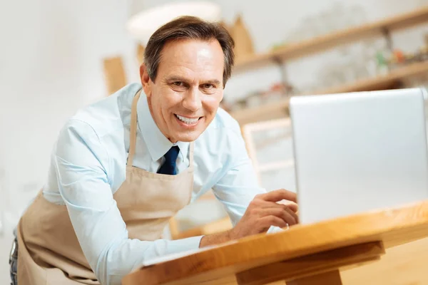 Гей задоволений чоловік посміхається і використовує ноутбук . — стокове фото
