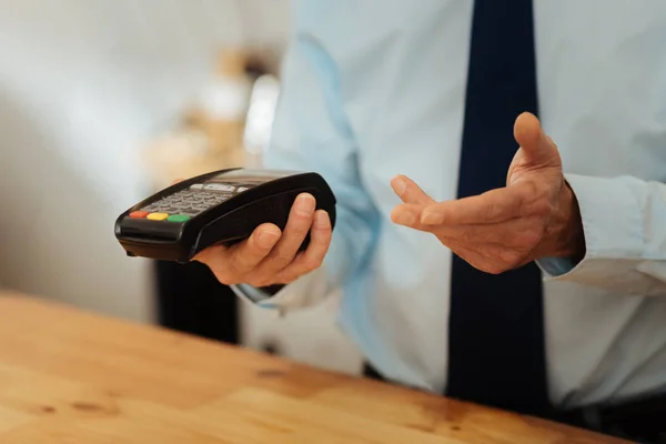 Senior occupied man holding the cash machine and gesticulating. — Stock Photo, Image