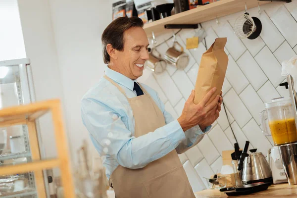 Joyful pleasant man standing and holding the pack. — Stock Photo, Image