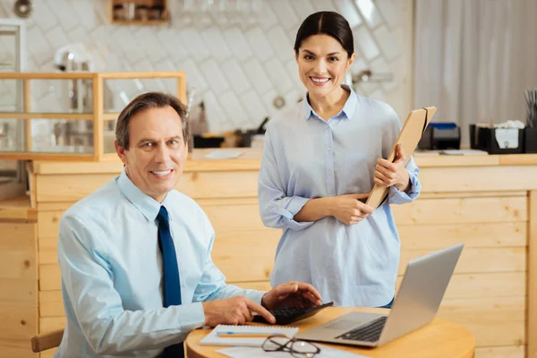 Agradable hombre satisfecho sentado y usando el portátil . —  Fotos de Stock