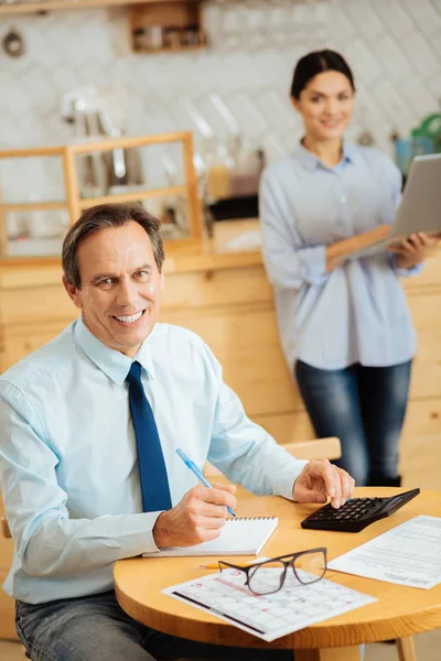 Lächeln beschäftigter Mann, der gerade schaut und berechnet. — Stockfoto