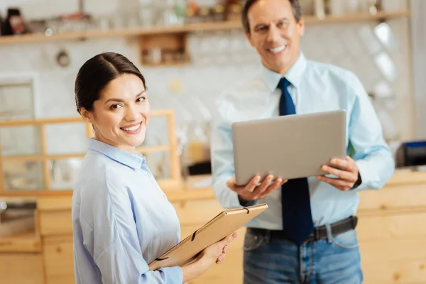 Zeker mooi uitziende vrouw permanent en houden de map. — Stockfoto