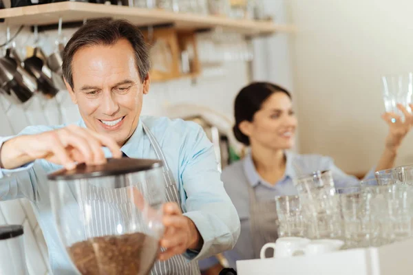 Zainteresowany odpowiedzialny człowiek stojący i parzenia kawy. — Zdjęcie stockowe