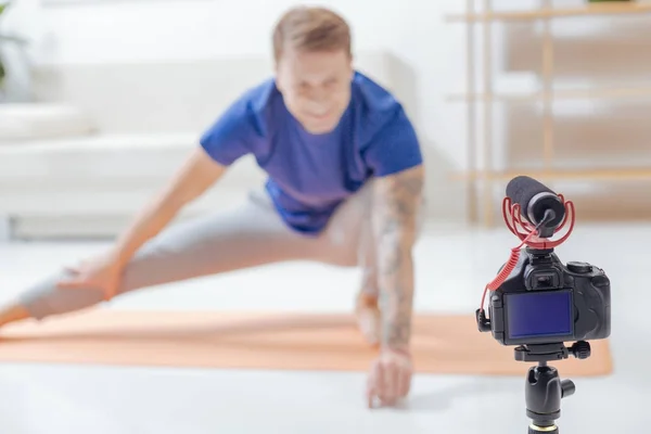 Blogueiro energético sorrindo enquanto grava um novo exercício — Fotografia de Stock