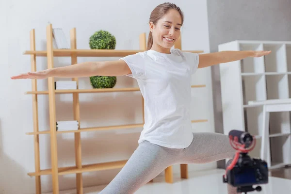 Positiv blogger leende till kameran samtidigt öva yoga — Stockfoto