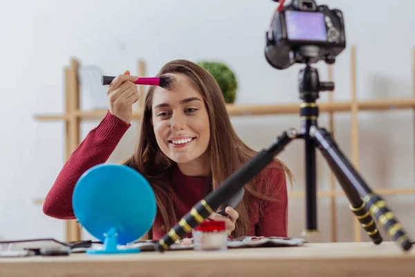 Blogueiro de moda agradável testando incrível pó facial e se sentindo satisfeito — Fotografia de Stock