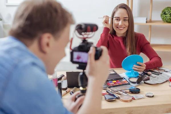 Happy módní blogger testování kosmetiky, zatímco její přítel nahrávání — Stock fotografie