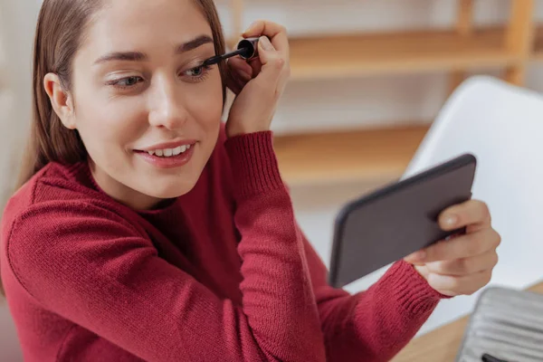 Porträt einer jungen Frau, die ihre Wimperntusche aufsetzt — Stockfoto