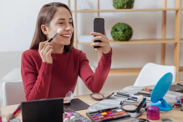 Blogger entusiasmado colocando em sua maquiagem com um novo pincel — Fotografia de Stock