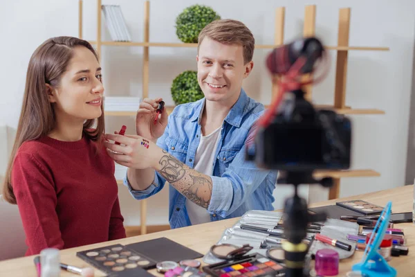 Pålitlig erfaren person gör makeup för hans assistent — Stockfoto