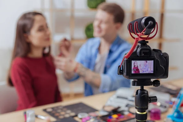 Vänliga människor sitter framför en kamera och gör makeup — Stockfoto