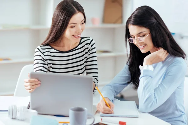 Compañeras alegres observando ideas —  Fotos de Stock