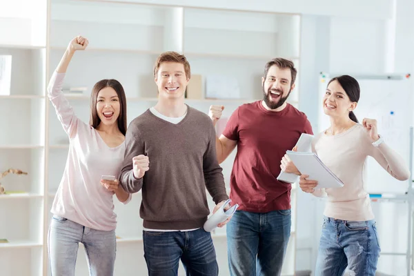 Charming four colleagues celebrating victory — Stock Photo, Image