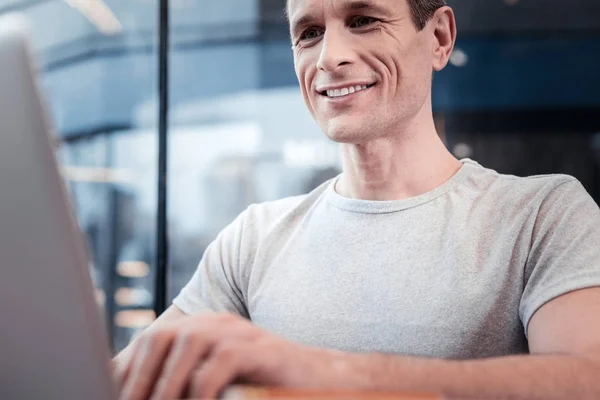 Close-up van glimlachende man die kijken naar laptop — Stockfoto