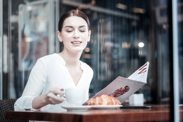 Mujer joven concentrada tomando taza —  Fotos de Stock